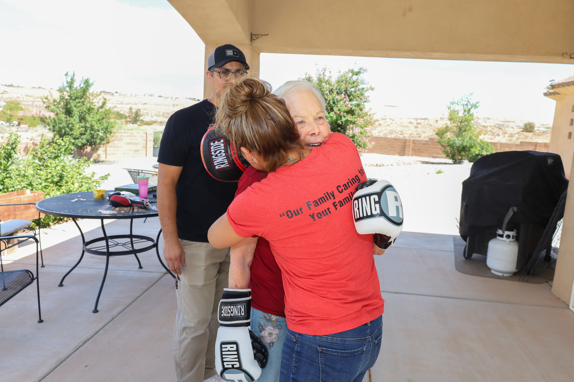 Casita caregiver and resident sharing a warm hug after a light boxing activity
